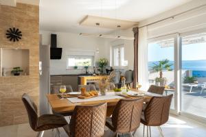 a dining room and kitchen with a table and chairs at Villa Antares in Duće