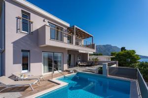 a villa with a swimming pool and a house at Villa Antares in Duće