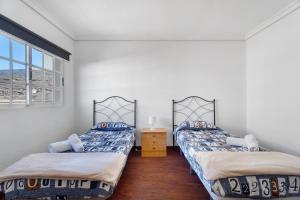 2 Betten in einem Zimmer mit 2 Fenstern in der Unterkunft Villa Vinco Tijoco Bajo Con Piscina in Adeje
