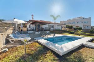 ein Haus mit Pool und Sonnenschirm in der Unterkunft Villa Vinco Tijoco Bajo Con Piscina in Adeje