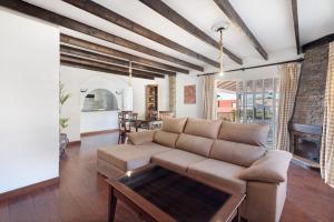 ein Wohnzimmer mit einem Sofa und einem Tisch in der Unterkunft Villa Vinco Tijoco Bajo Con Piscina in Adeje