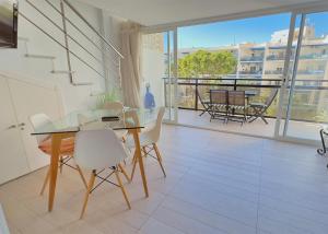 une salle à manger avec une table en verre et des chaises blanches dans l'établissement Skol 206 Marbella, à Marbella