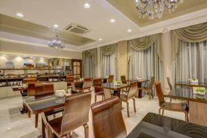 a restaurant with wooden tables and chairs and a buffet at Hotel Lulu in Bishkek