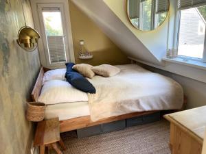een slaapkamer met een bed met kussens erop bij "Zonnekind" Atmospheric holiday home in Noordwijkerhout near the beach in Noordwijkerhout