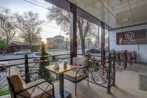 a table and chairs on a balcony with a view of a street at Hotel Lulu in Bishkek