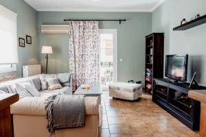a living room with a couch and a tv at Va Yia/ Spacious guest house in Nafplio