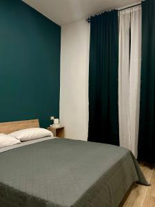 una camera con letto e parete verde di Antico Borgo Rooms a Napoli