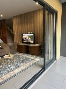 uma sala de estar com uma televisão e uma porta de vidro deslizante em Luxurious Ballito Self Catering Family Holiday Home em Ballito