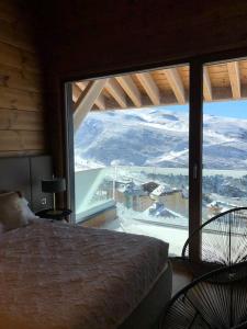 a bedroom with a bed and a large window at Arttysur Lux Village Sierra Nevada Casa 8 Superlujo in Sierra Nevada