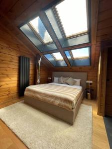 a bedroom with a large bed with a skylight at Arttysur Lux Village Sierra Nevada Casa 8 Superlujo in Sierra Nevada