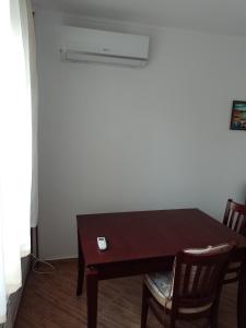 a dining room table with chairs and a white wall at Цвят бяло in Sofia