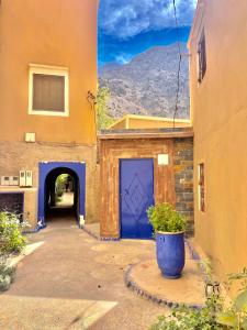 un edificio con una porta blu e un tunnel di Toubkal home stay a Imlil