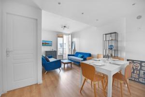 een woonkamer met een witte tafel en blauwe stoelen bij T3 Hyper Centre - Chaleureux et lumineux in Toulouse