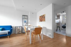 een eetkamer en een woonkamer met een witte tafel en stoelen bij T3 Hyper Centre - Chaleureux et lumineux in Toulouse