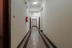 an empty hallway with a fire extinguisher on the wall at Emara Grand Hotel in Bangalore