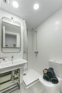 a bathroom with a sink and a toilet and a mirror at Sausalito Canteras by Canarias Homelidays in Las Palmas de Gran Canaria