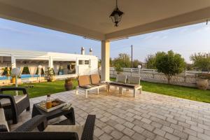 a patio with chairs and a table on a patio at Villa Alexandra - IsulaTravel in Ispica