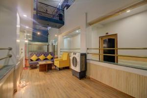 OYO SilverKey Hotel Manas Residency في مومباي: غرفة معيشة مع أريكة وتلفزيون