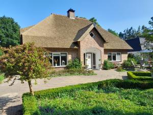 a brick house with a shingled roof at Bed and Breakfast De Kleine Vos in Elspeet