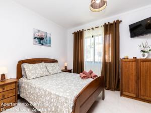 - une chambre avec un lit et 2 chaussons roses dans l'établissement Akisol Albufeira Sunny, à Roja- Pé