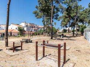 un parc avec des bancs, des tables de pique-nique et des arbres dans l'établissement Akisol Albufeira Sunny, à Roja- Pé