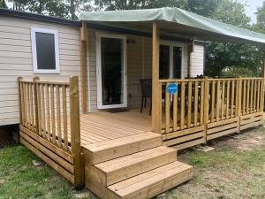 una terraza de madera con cenador en una casa en Camping de Montlouis-sur-Loire, en Montlouis-sur-Loire