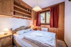 Schlafzimmer mit einem großen Bett und Holzwänden in der Unterkunft Appartement T3 Chatel in Châtel