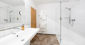 a white bathroom with two sinks and a shower at Best Western Plus iO Hotel in Eschborn +66 photos