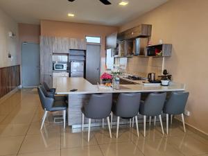 a kitchen with a large island with chairs in it at Kensington Sunrise at Sg Palas,PalasHorizon in Tanah Rata
