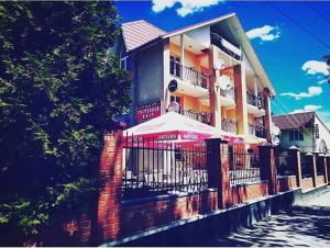 a building with an umbrella in front of it at Galant Hotel in Boryspilʼ +25 photos