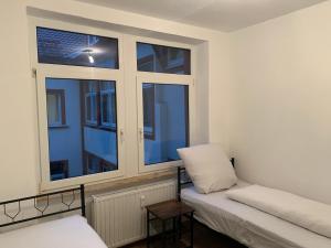 a small room with two windows and a couch at Monteurwohnung Heilbronn nahe Neckarsulm in Heilbronn