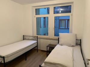 two beds in a room with two windows at Monteurwohnung Heilbronn nahe Neckarsulm in Heilbronn