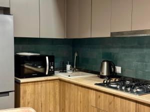 a kitchen with a microwave and a stove top oven at Downtown Apartment in Kutaisi