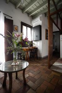 塞維利亞的住宿－Casa del siglo XVII，客厅里设有一张桌子,上面有花瓶