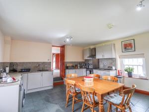 a kitchen with a wooden table and chairs at High Shaftoe in Longwitton