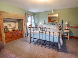 a bedroom with a bed with a mirror and a fireplace at High Shaftoe in Longwitton