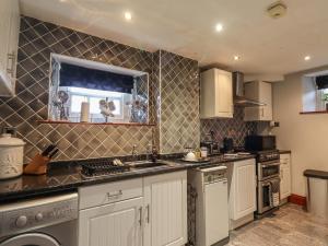 a kitchen with a sink and a stove at West View in Longwitton