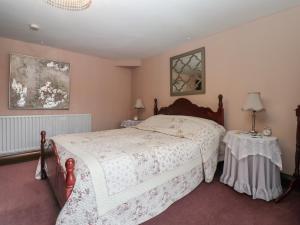 a bedroom with a large bed and two tables at West View in Longwitton