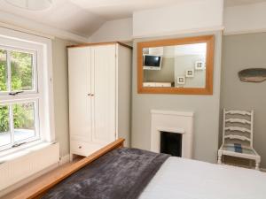a bedroom with a bed and a mirror at Tor Cottage in Salcombe