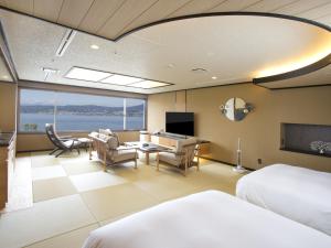 una camera d'albergo con due letti e un soggiorno di Hamanoyu a Suwa