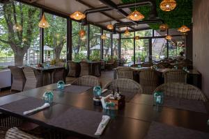 a restaurant with tables and chairs and windows at Grand Hotel Riga in Ruse