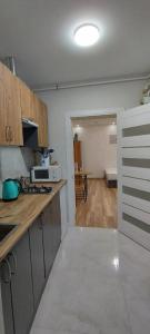 a kitchen with a counter and a room with a table at Apartments of Lesya Ukrainka St. 25 in Lviv