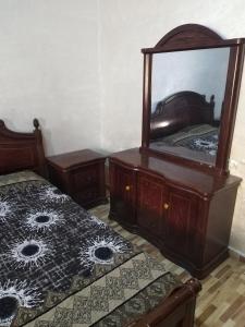 a bedroom with two beds and a mirror on a dresser at شقة ام نوارة الحديثة in Amman