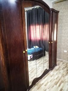 einen Spiegel in einem Zimmer mit einem Bett in einem Schlafzimmer in der Unterkunft شقة ام نوارة الحديثة in Amman