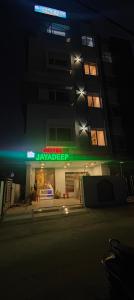 un bâtiment avec un panneau de néon sur lui la nuit dans l'établissement Hotel Jayadeep, à Bhubaneswar