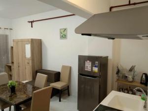 una cucina con tavolo e frigorifero in acciaio inox di M&M Royal Oceancrest Mactan a Sudtungan