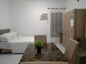 a room with a table and a bed and a bedroom at M&M Royal Oceancrest Mactan in Sudtungan