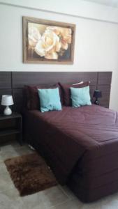 sypialnia z łóżkiem z fioletowymi prześcieradłami i kwiatami w obiekcie HOTEL JOINVILLENSE w mieście Joinville
