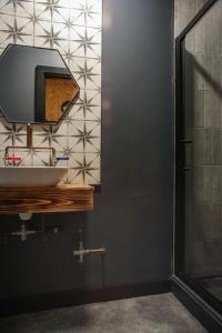 La salle de bains est pourvue d'un lavabo et d'un miroir. dans l'établissement OYO The Studio, à Swansea