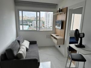 a living room with a couch and a large window at TrevizZo Allianz Parque in Sao Paulo